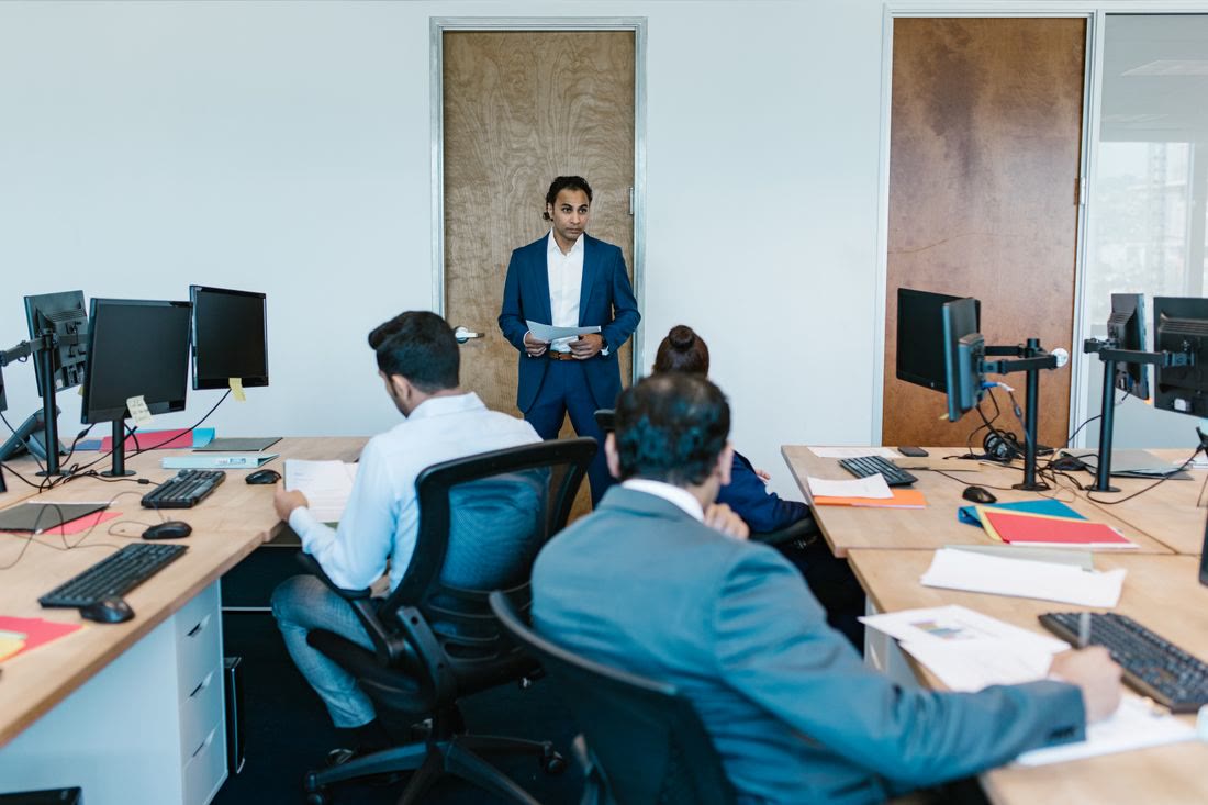 An office team at their workstations during a short briefing